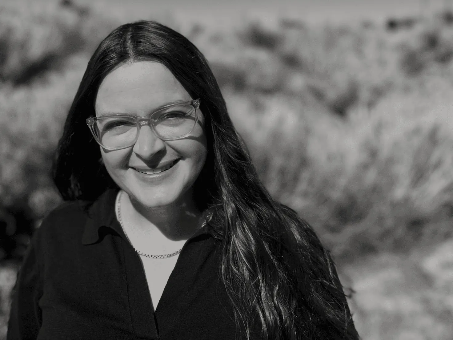 Black and white portrait of Elizabeth Korb outdoors in high desert brush